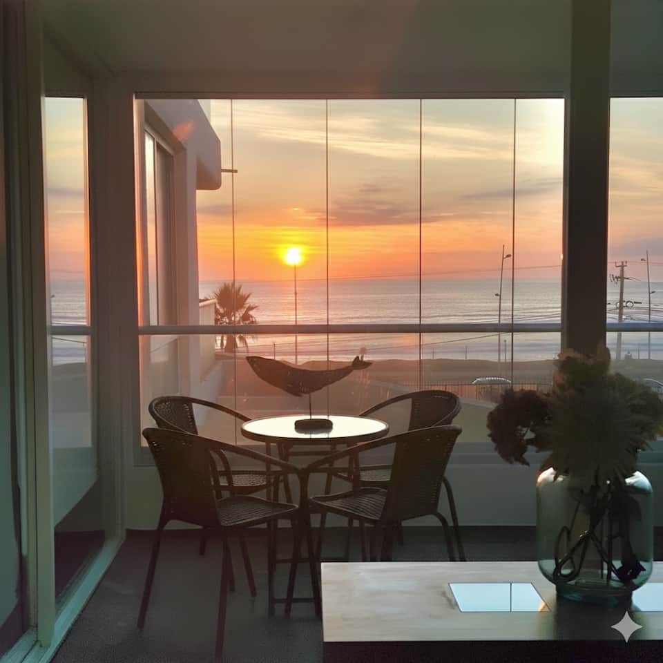 Atardecer desde la terraza acristalada del departamento Neohaus, frente al mar